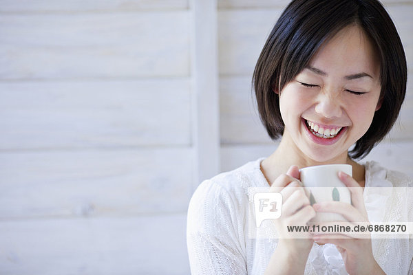 Young Woman With Coffee Cup Laughing