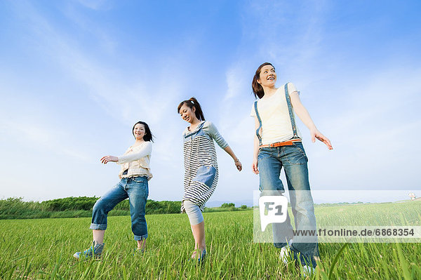 Three Young Women Walking in Field