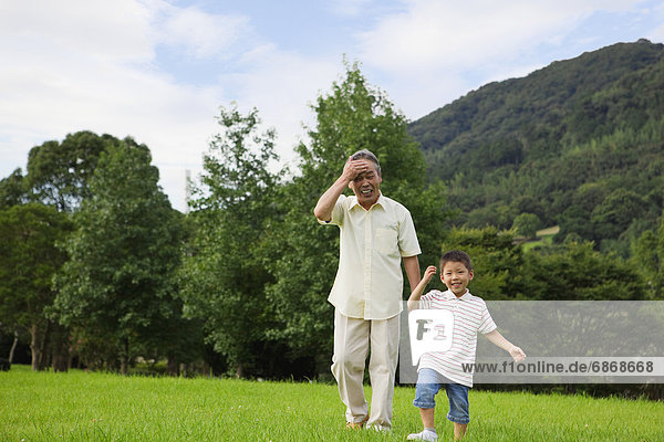 Grandfather and Grandson Walking in Park