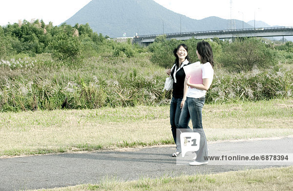 Young women holding a file and walking