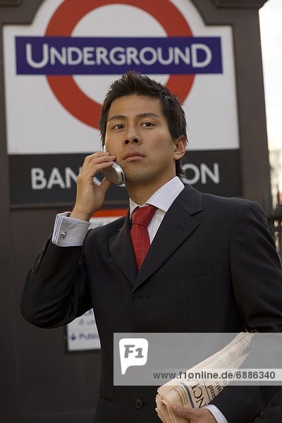 The businessman who applies a cellular phone at the subway entrance in London