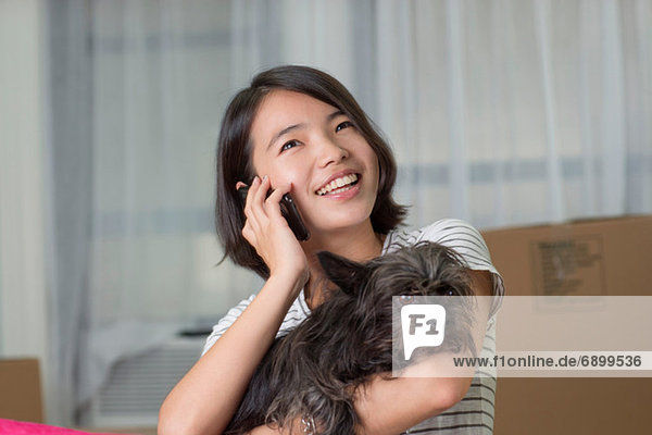 Junge Frau auf dem Handy mit Hund