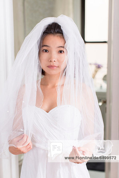 Junge Frau im Brautkleid mit Schleier