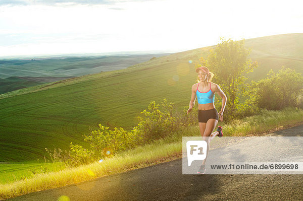 Young woman running in landscape of Palouse Hills  Washington  USA