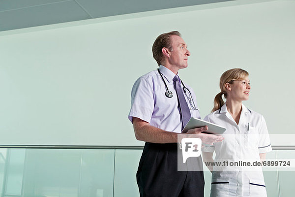 Doctor holding digital tablet with nurse