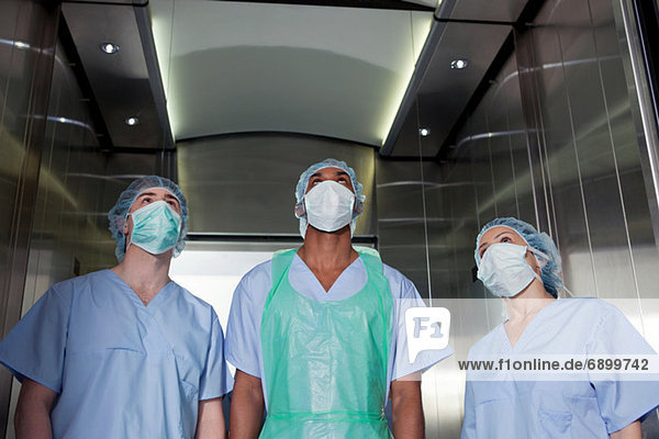 Drei Chirurgen im Krankenhausaufzug