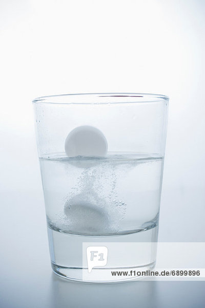 Pille im Glas Wasser