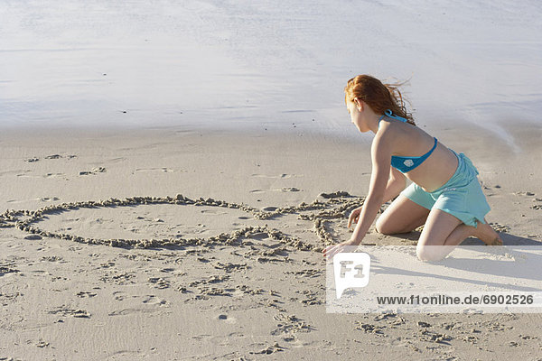 Girl Drawing in the Sand