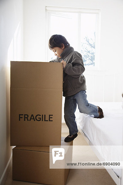 Child on Bed with Box in Room