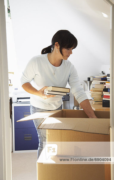 Woman Packing Books into Box