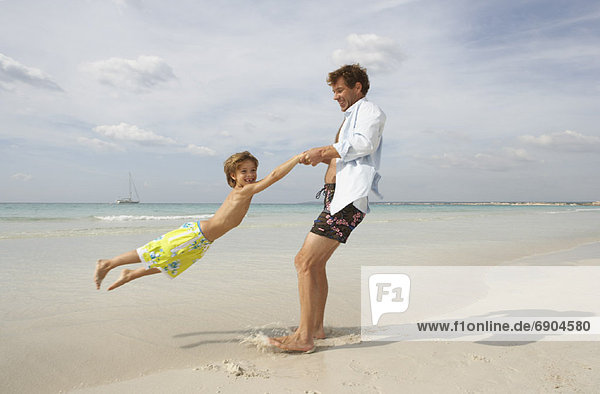 Father Playing with Son on Beach  Majorca  Spain