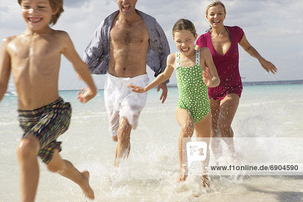Family Running along Beach  Majorca  Spain