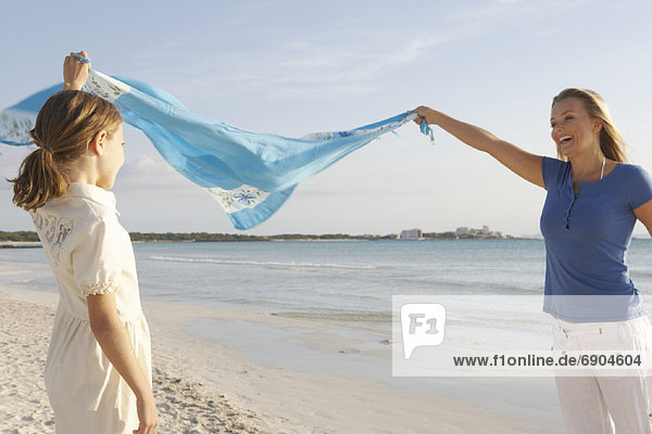 Mother and Daughter Holding Sarong in Wind  Majorca  Spain