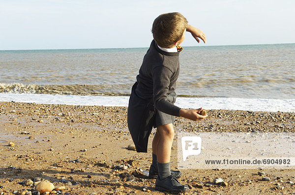 Boy Throwing Rocks at the Beach