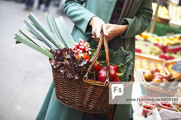 Woman Carrying Basket Full of Vegetables