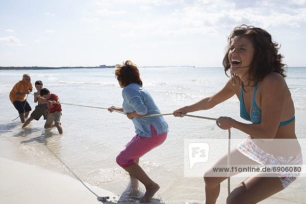 Family Playing Tug-of-War on the Beach