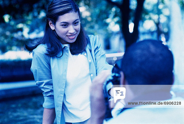 Man Taking Picture of Woman Outdoors