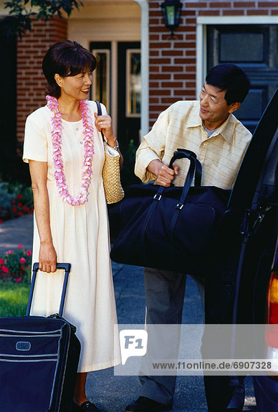 Mature Couple Unloading Luggage From Van