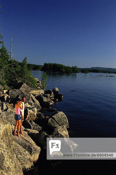 Couple Standing on Rocks near Lake  Belgrade Lakes  Maine  USA