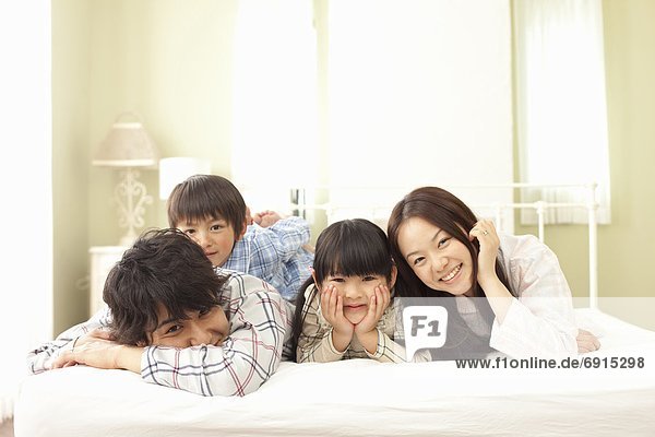 Parents and Two Children Lying in Bed
