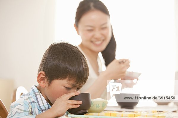 Mother Watching Son Eating Soup