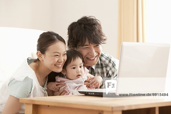 Mother  Father and Baby Girl Using Laptop