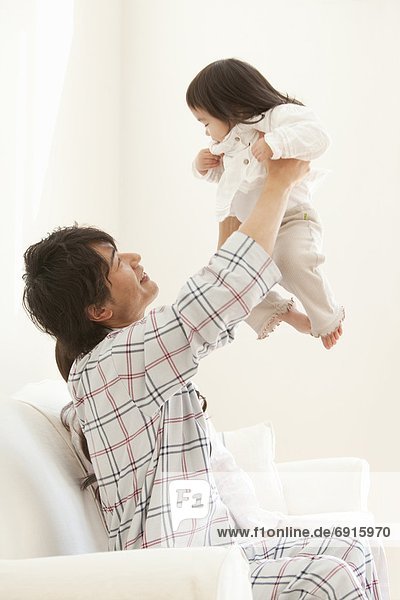 Father Holding Baby Girl Aloft