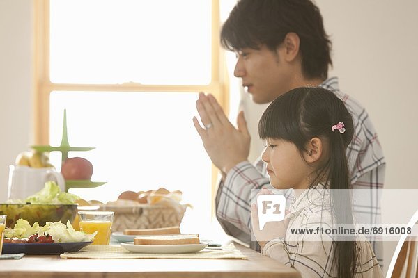 Father and Daughter Praying at Breakfast Table