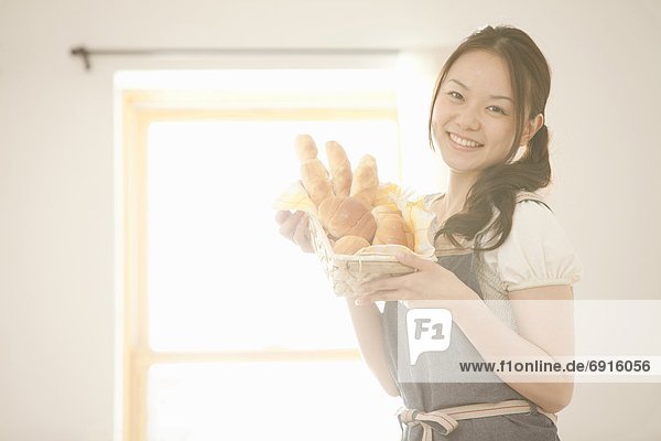 Young Woman Holding Bread Basket