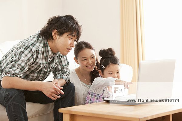 Parents and Daughter Using Laptop