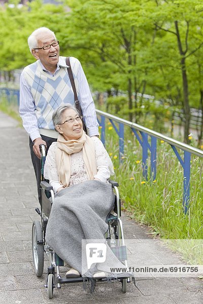 Senior Man Pushing Wife in Wheelchair