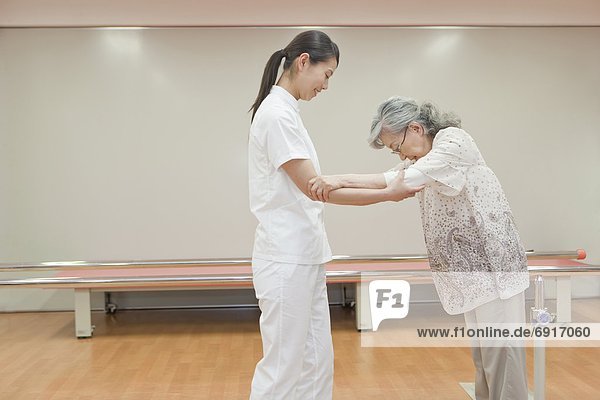 Nurse helping a senior woman walk  Kanagawa Prefecture  Honshu  Japan