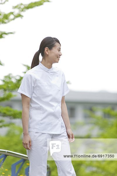 Healthcare worker standing in park  Kanagawa Prefecture  Honshu  Japan