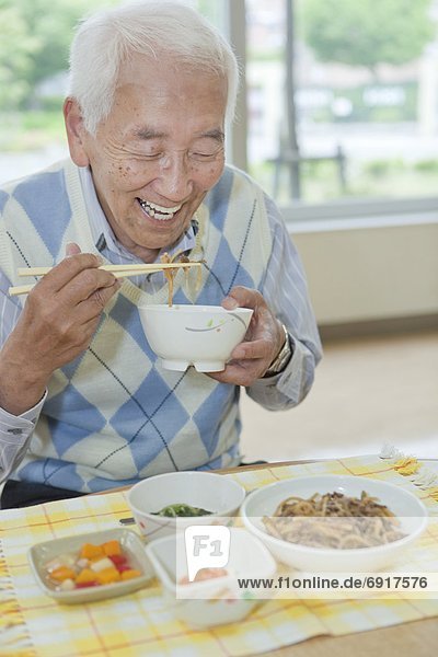 Senior man eating food  Kanagawa Prefecture  Honshu  Japan