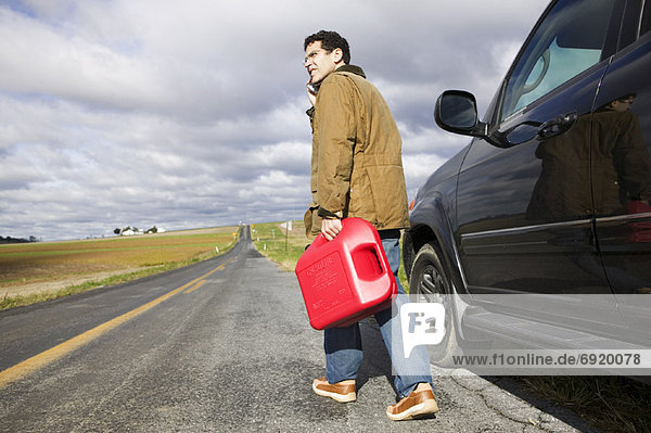 Man Carrying Gas Can on Country Road