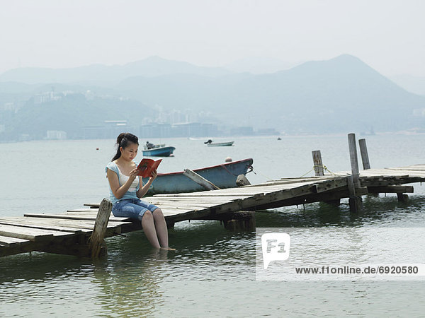 Woman Reading on Dock