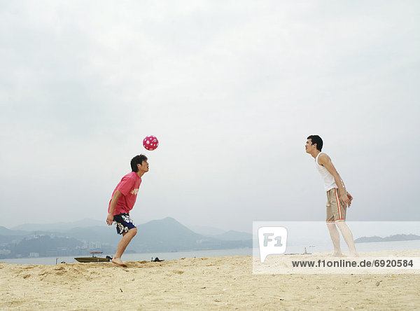 Men Playing With Ball on Beach