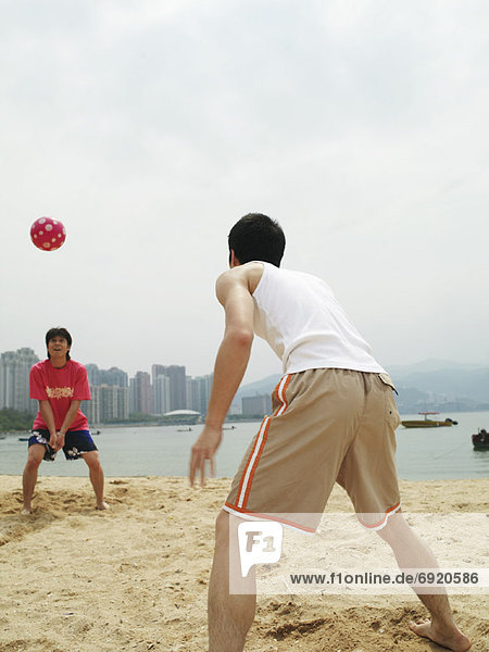 Men Playing With Ball on Beach