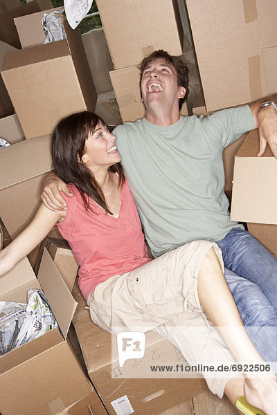 Couple Sitting Amongst Moving Boxes