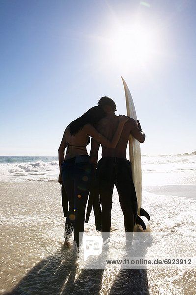 Couple with Surfboard at Beach