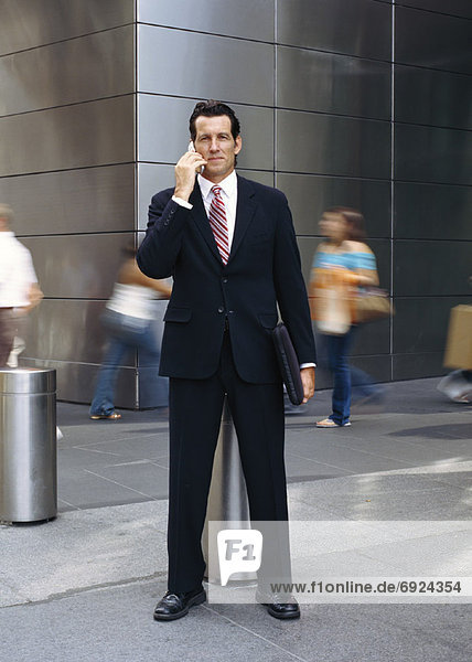 Portrait of Businessman Standing Outdoors  Talking On Cellular Phone