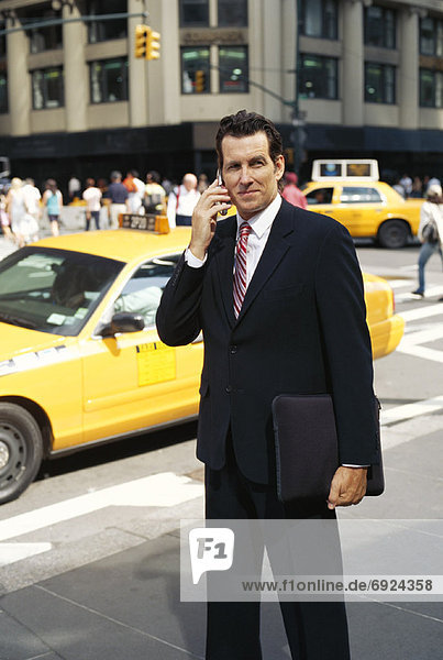 Businessman with Cellular Phone on Sidewalk