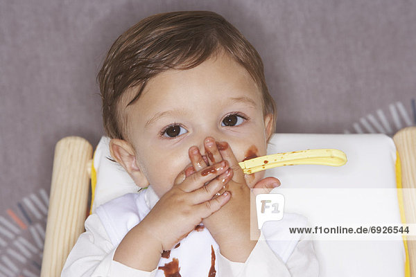 Baby Eating Pudding in High Chair