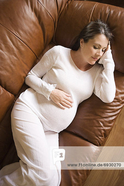 Schwangere Frau schlafen auf Sofa