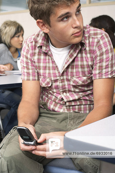 Student mit Handy im Klassenzimmer