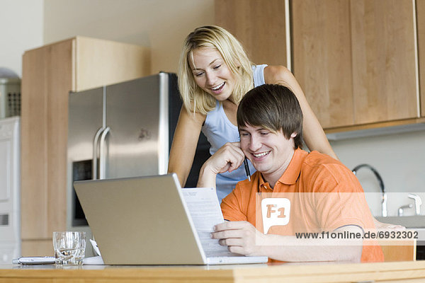 Couple in Kitchen with Laptop Computer
