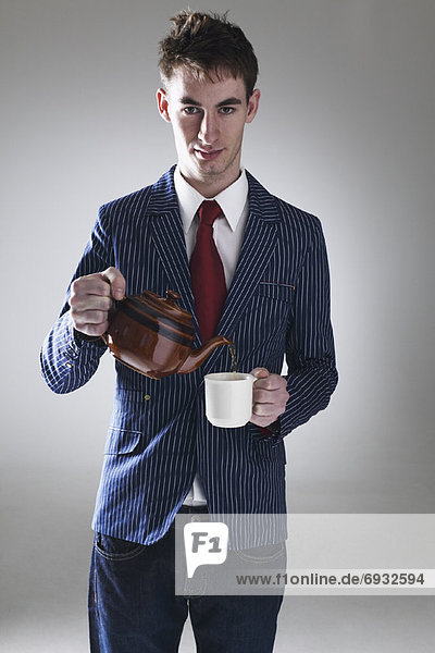 Young Man Pouring Cup of Tea