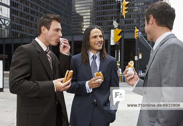 Businessmen Eating Hot Dogs