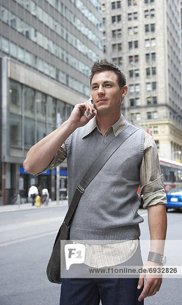 Man Standing on Street Using Cellular Phone