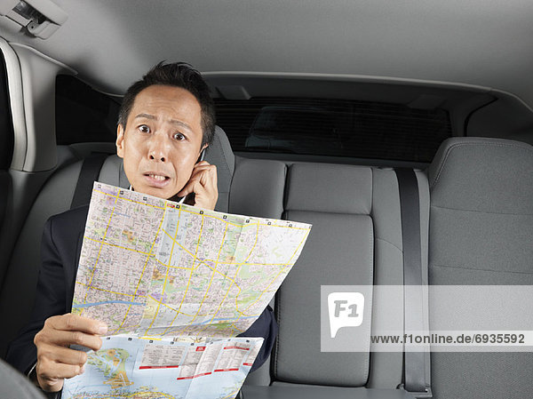 Businessman Looking at Map in Car